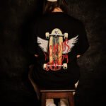 girl wearing Vicious Candy oversized black tee with skate and wings.