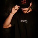 Man wearing oversized black tee and streetwear black cap